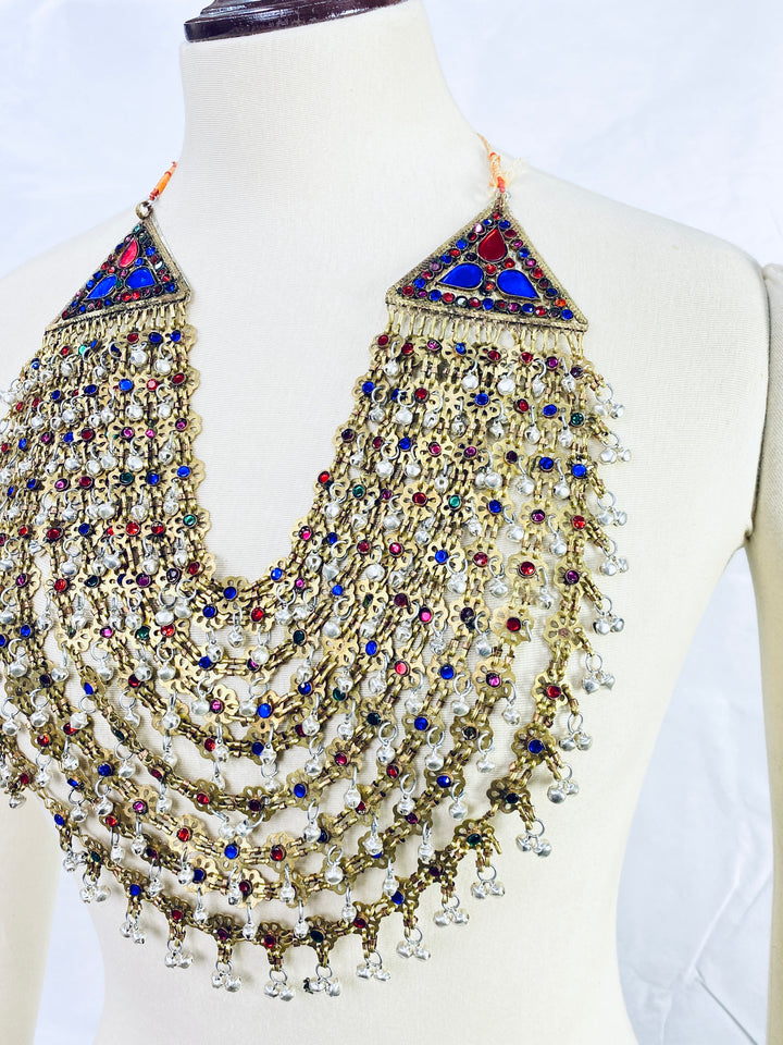 Ornate necklace with multicolored stones on a mannequin against a white background
