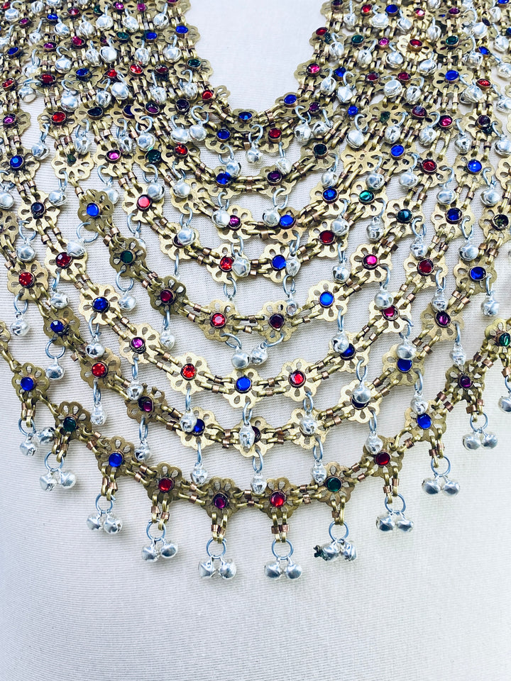 Multiple necklaces with colorful beads and gold chains on a light background