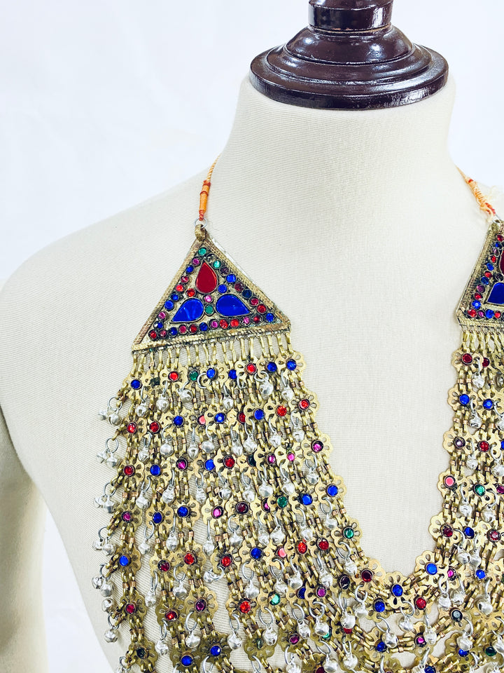Decorative necklace with colorful stones on a mannequin against a white background