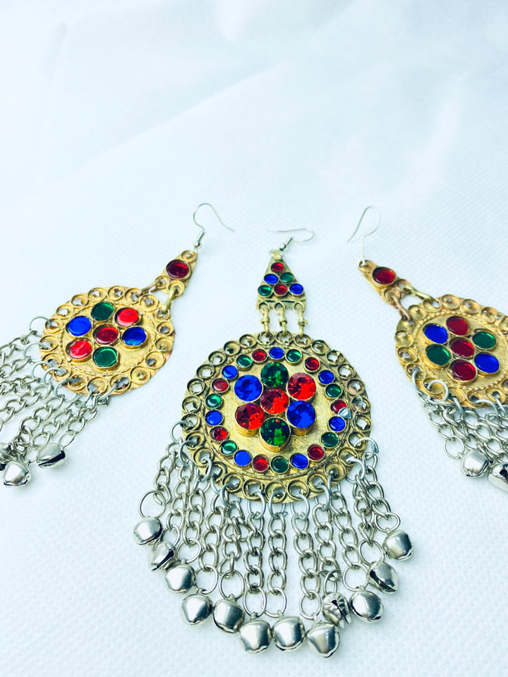 Colorful earrings with gemstones and chain details on a white background