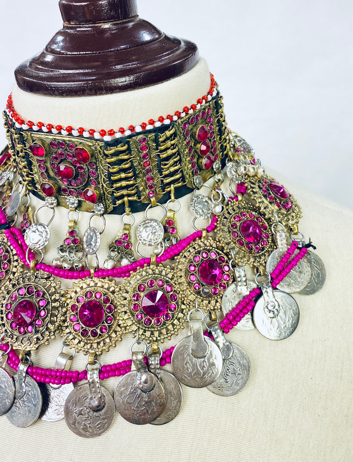 Ornate necklace with pink and silver elements on a mannequin against a white background