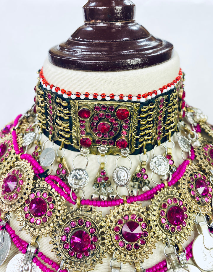 Ornate jewelry set with red and gold accents on a mannequin.
