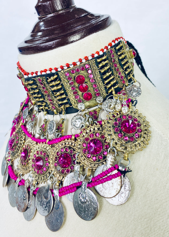 Decorative belt with pink and gold embellishments on a mannequin.