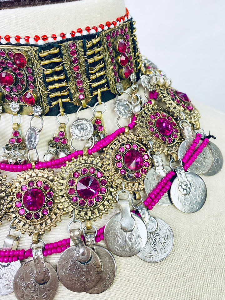 Ornate jewelry set with pink and silver elements on a white background
