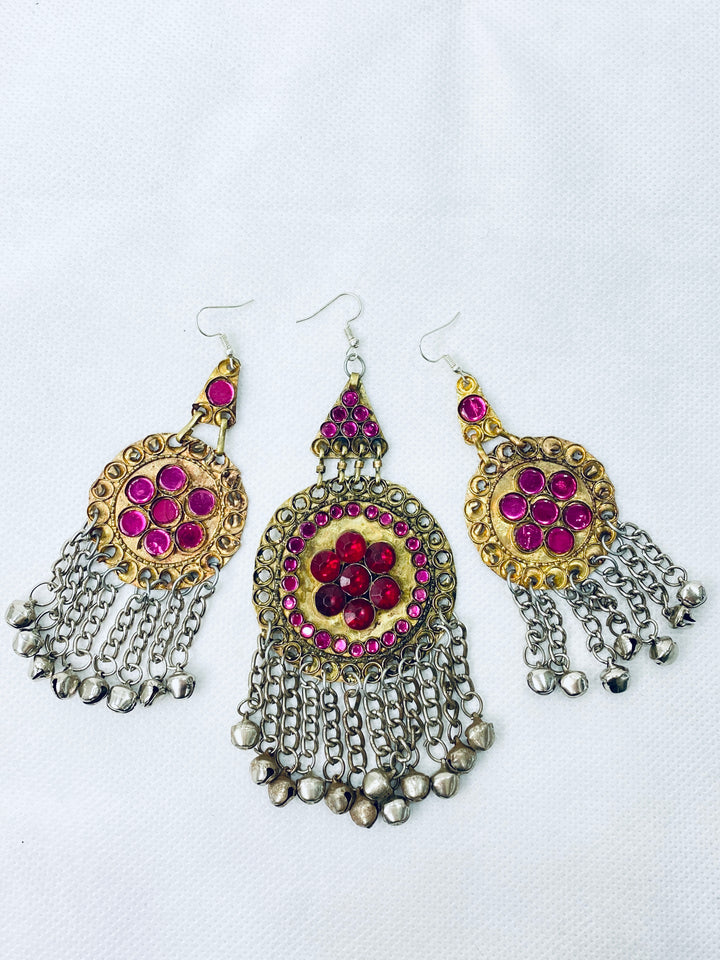 Ornate earrings with pink gemstones and chain details on a white background