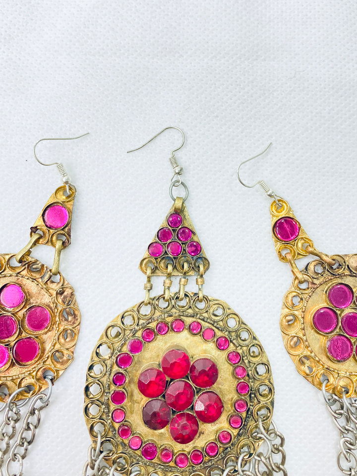 Ornate earrings with pink gemstones on a white background
