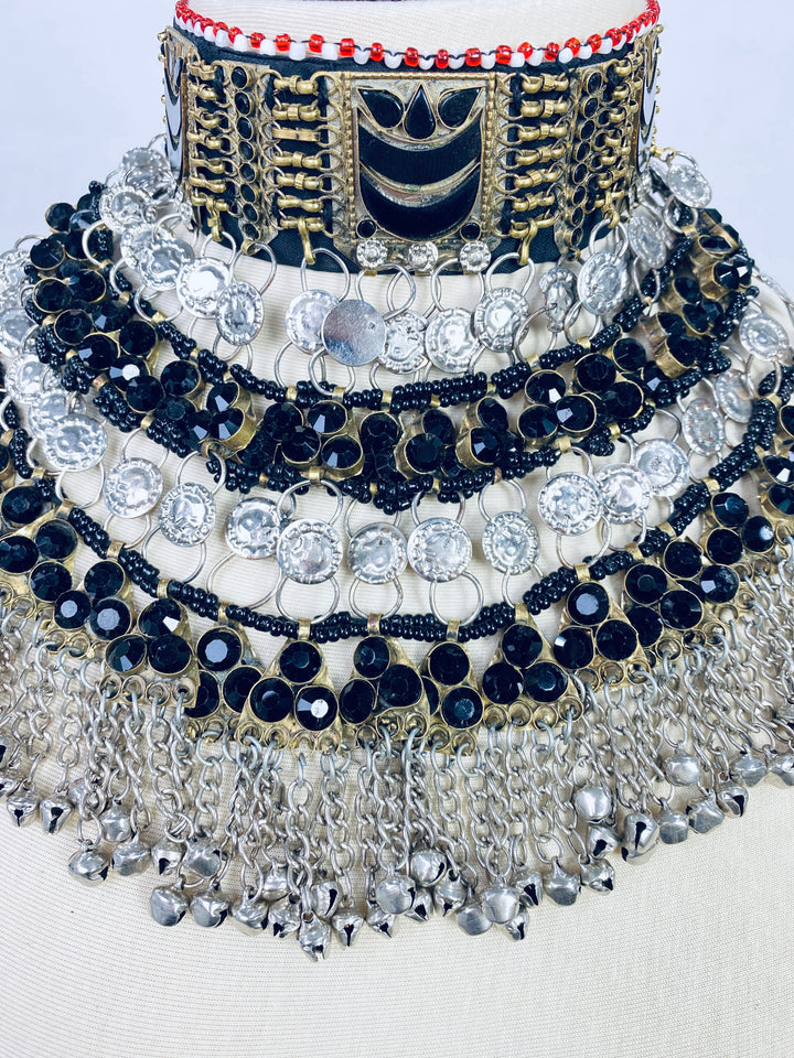Decorative necklace with black, gold, and silver elements on a white background