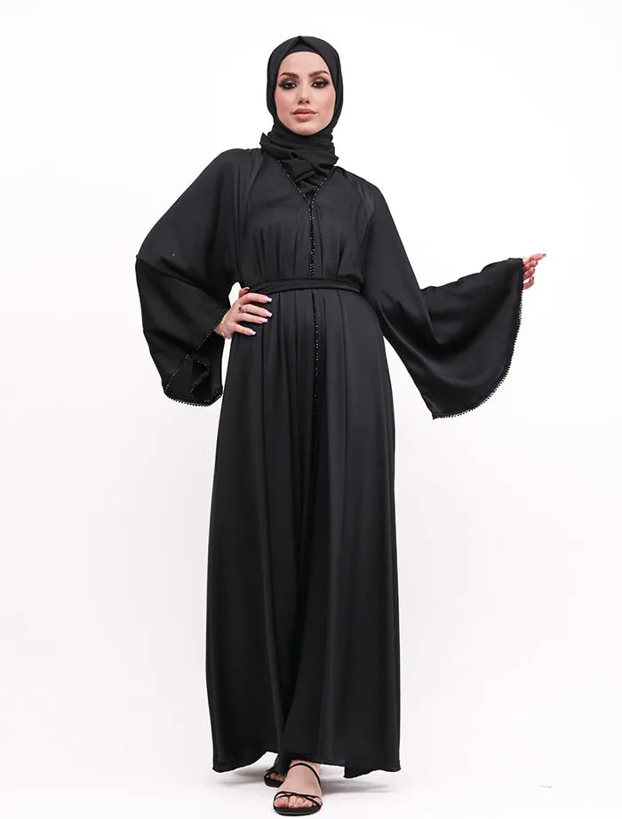 Makeba Pearl Abaya near me with elegant satin fabric, dramatic umbrella cut, and modern black detailing. Shop abayas for sale in the UK