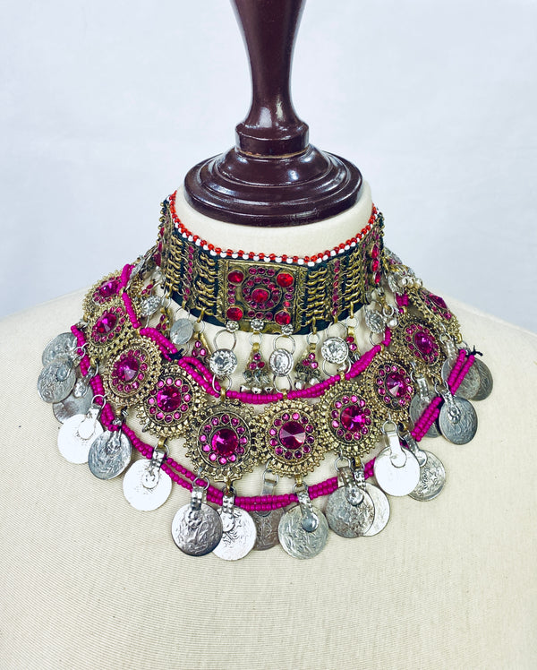 Ornate necklace with pink and silver elements on a mannequin against a white background